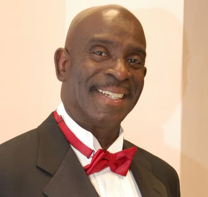 Cleve Osborne smiling in a suit with a red bow tie